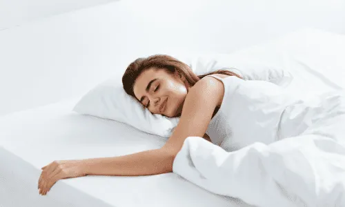 Frau schläft entspannt in frisch gereinigtem Bett