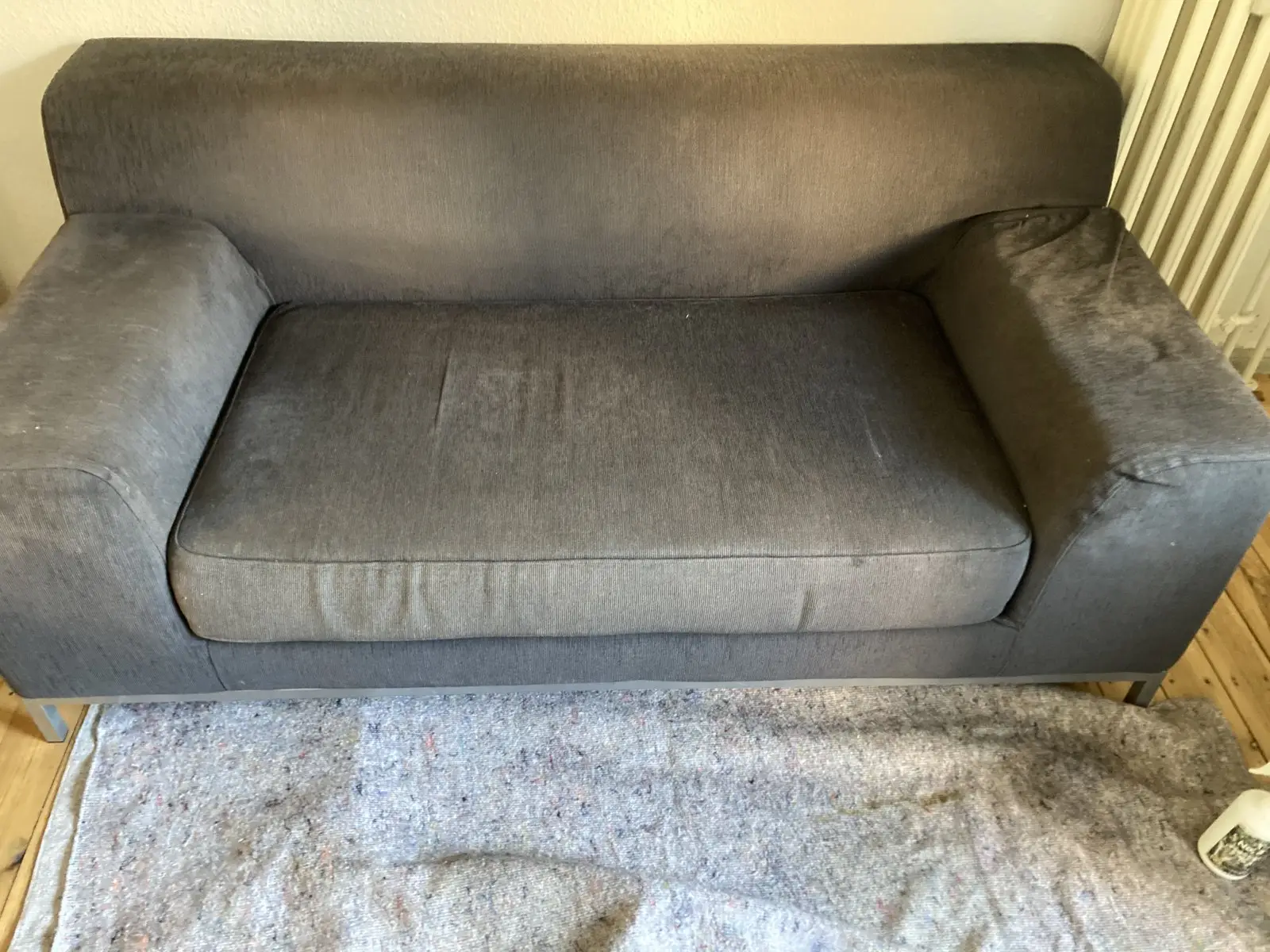 Vorher: graues Sofa mit verschmutzter Sitzfläche und Armlehnen