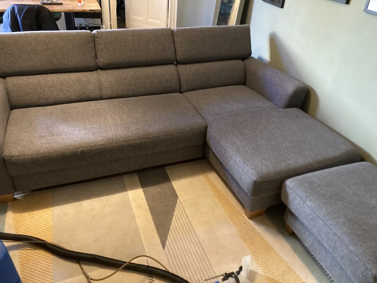 Nachher: graues Ecksofa mit großem Fleck auf der Sitzfläche