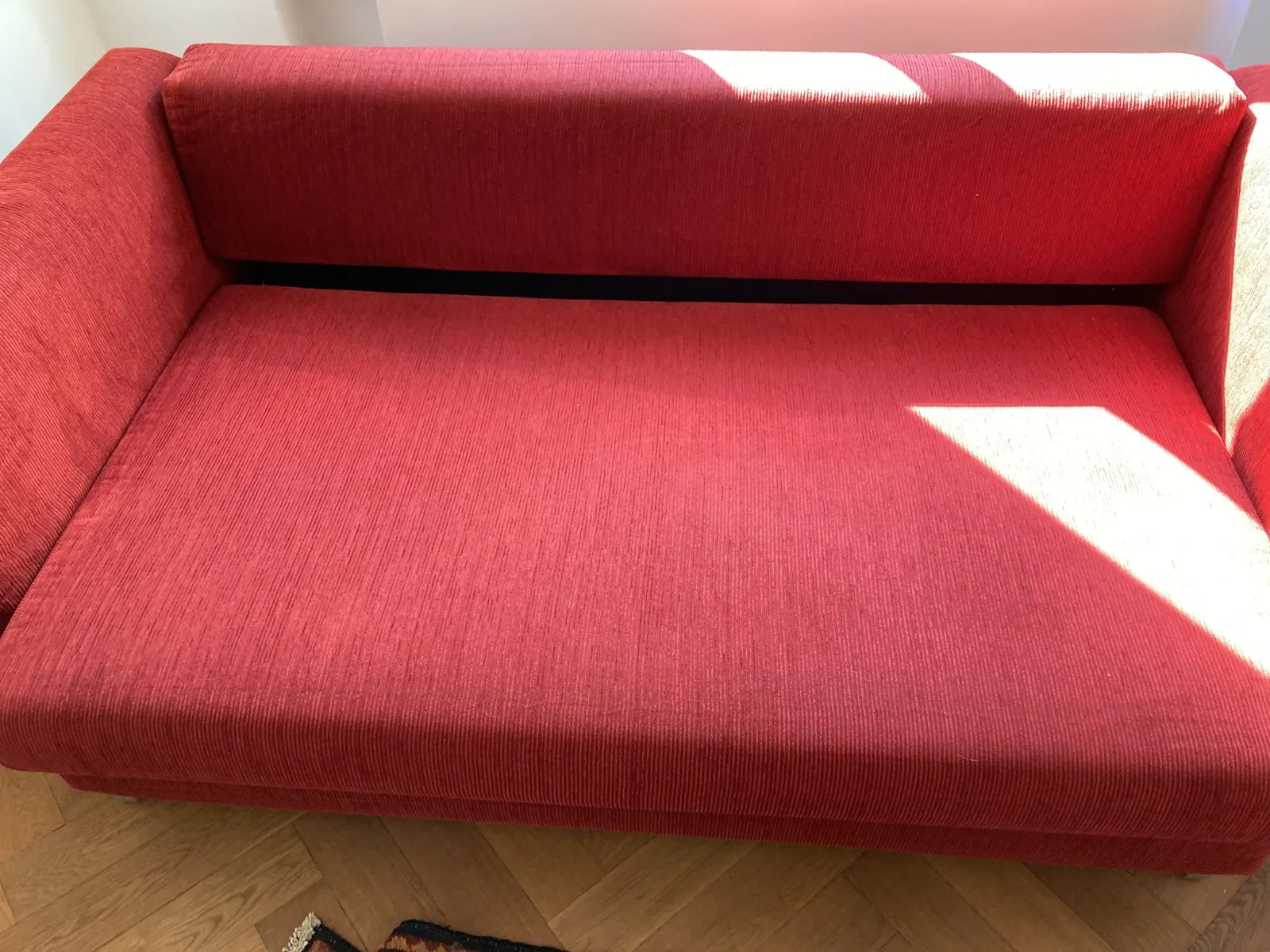 Nachher: rotes Sofa mit Flecken auf der Liegefläche